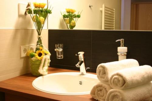 圣瓦伦蒂诺阿拉穆塔玛尔酒店的浴室水槽配有毛巾和花瓶