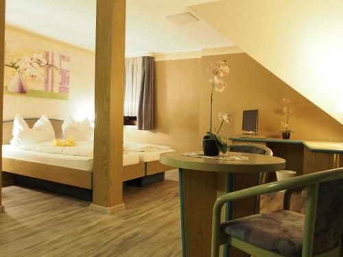 奥滕多夫-欧克里拉Pension Ottendorf-Okrilla的酒店客房配有一张床铺和一张桌子。