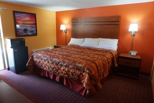 瓦恩兰RELAX INN的酒店客房设有一张大床和两盏灯。