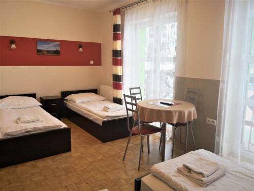 拉伊恰Leniwy Motyl的客房设有两张床、一张桌子和一扇窗户。