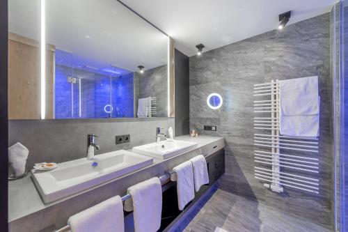 图克斯Aktiv- & Wellnesshotel Bergfried的一间带两个盥洗盆和大镜子的浴室
