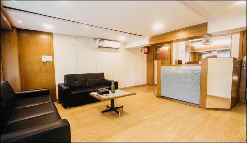 孟买Qubestay Airport Capsule Hotel & Hostel的客厅配有沙发和桌子