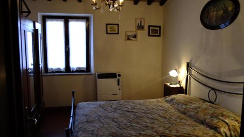 波吉邦西Podere Val di Gallo的一间卧室设有一张床和一个窗口