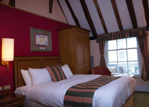 亨利昂泰晤士凯瑟琳维尔维特斯普恩酒店的一间卧室设有一张大床和一个窗户。