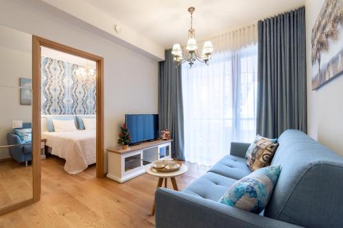 塔林Rotermann Square view Apartment的客厅配有蓝色的沙发和床。