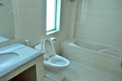 InāniInani Royal Resort的浴室配有卫生间、盥洗盆和浴缸。