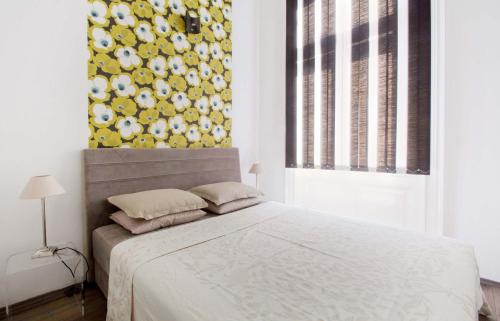 布达佩斯Andrassy Boulevard的一间卧室配有一张黄色和白色墙壁的床