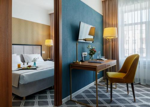 巴尔瑙尔Altay Hotel的一间卧室配有一张床和一张桌子及椅子