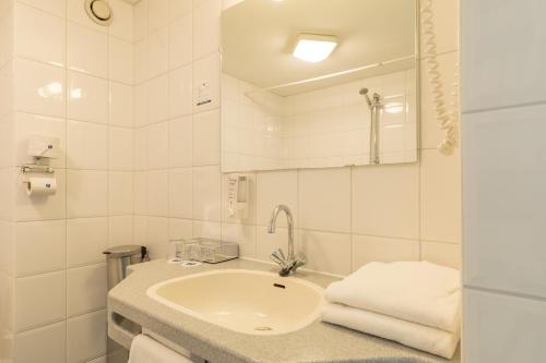 霍勒姆Fletcher Hotel-Restaurant Amelander Kaap的白色的浴室设有水槽和镜子