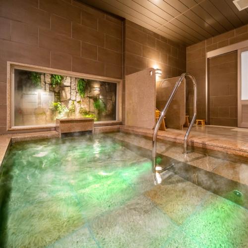 饭田市Super Hotel Nagano Iida Inter的浴室内设有一个大型游泳池及水滑梯