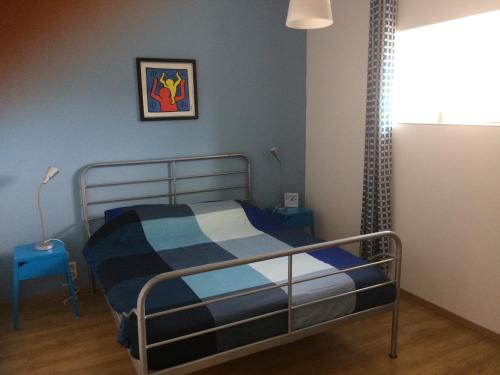 Bussière-PortevineGÎTE Les Buis的一间卧室配有一张蓝色墙壁的床