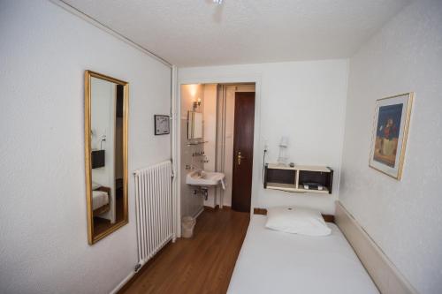 日内瓦圣热尔韦酒店的一间白色的小房间,配有床和水槽