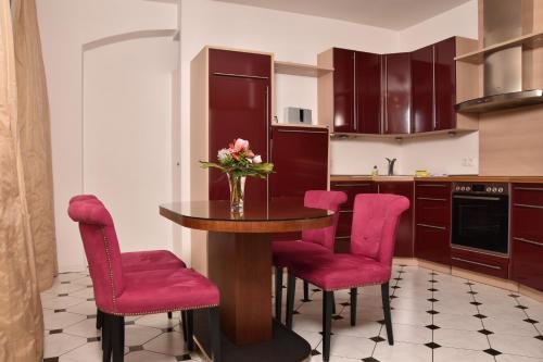 巴特尚道阿尔布雷彻斯伯格公寓式酒店的厨房配有桌子和粉红色的椅子