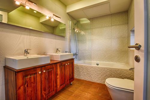 阿尔卜Aldo House的浴室配有2个盥洗盆、卫生间和浴缸。