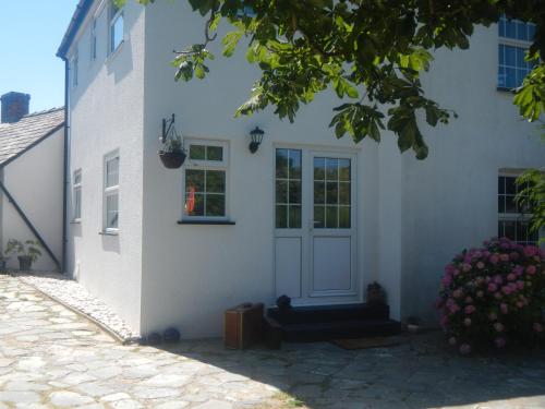 布德Boots Cottage的白色的房子,有门和窗户
