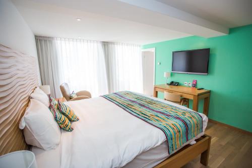 沃韦拉夏洛旅馆的一间卧室配有一张床和一台平面电视