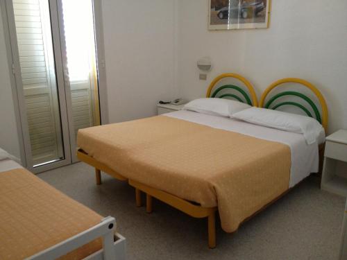 西尼加利亚Hotel Vienna的一间卧室配有两张床和彩虹床头板