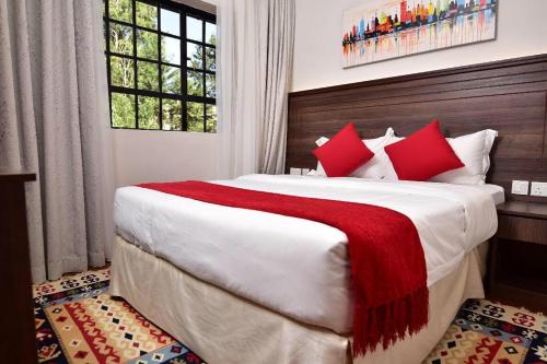 内罗毕Palm Valley的一间卧室配有一张带红色枕头的大床
