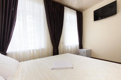 敖德萨克里斯特尔酒店的一间卧室配有一张带笔记本电脑的床