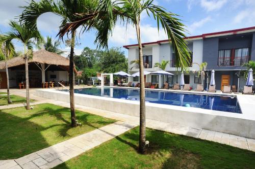 邦劳罗望子度假酒店的一个带游泳池和棕榈树的度假村