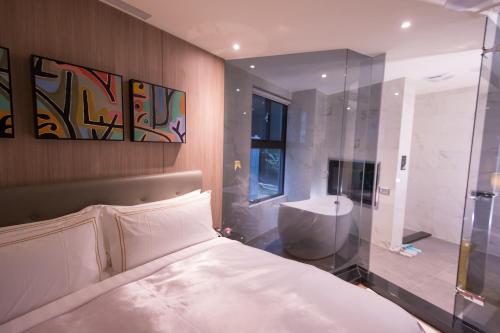 台北三重江月行馆的一间卧室配有一张床、淋浴和盥洗盆