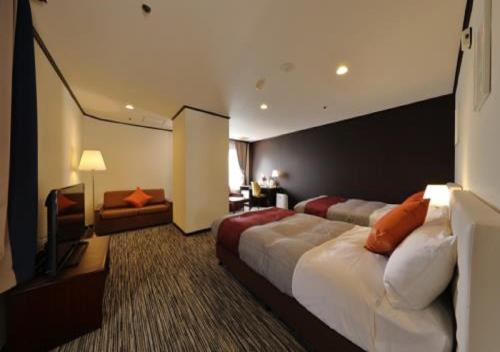 Matsuyama紫雲閣东松山花园酒店的酒店客房设有一张大床和一张沙发。