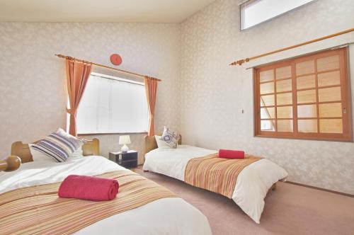 伊豆Villent Fujimi Hiekawa的一间卧室设有两张床和窗户。
