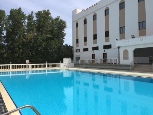 马斯喀特地那假日酒店的大楼前的大型游泳池