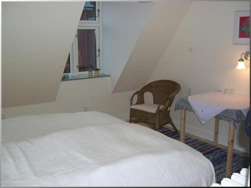 维堡克洛斯特裴森酒店的卧室配有1张床、1张桌子和1把椅子