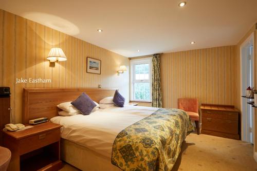 锡德茅斯希德谷乡村别墅酒店的配有一张床和一把椅子的酒店客房