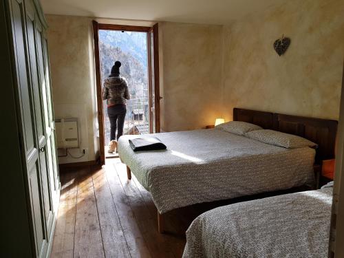Ornicacasa del cirillo的一位女士走进带两张床的卧室