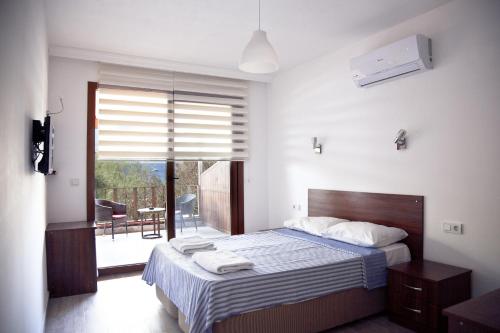 雅丽丝弗里克Şahin Motel & Restaurant的一间带大床的卧室和一个阳台