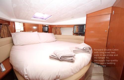 利明顿Zen Dog Luxury Motor Yacht的船上的一张床位,上面有毛巾