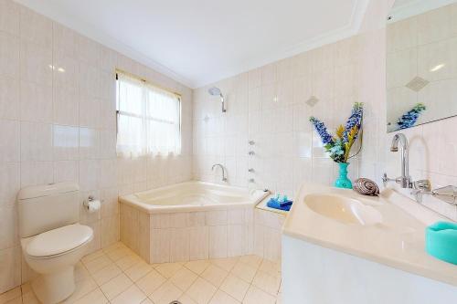 圣殿海岬Paradise Beach Apartments的浴室配有卫生间、浴缸和水槽。
