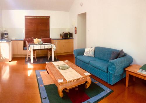 拜伦湾Byron Beach Cabin的客厅配有蓝色的沙发和桌子