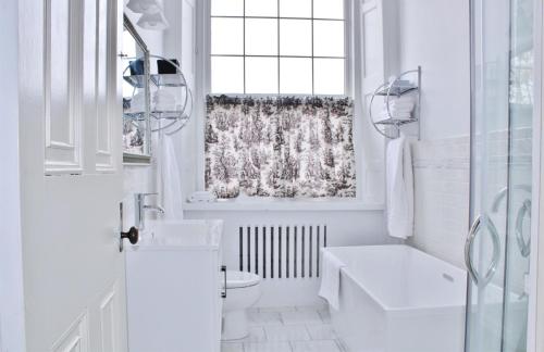 金斯顿惠特尼庄园全套房酒店的白色的浴室设有卫生间和窗户。