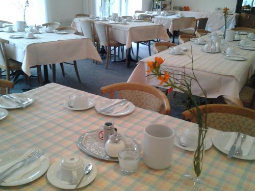 菲尔德施塔特兹莫尔曼酒店的用餐室配有桌椅和白色桌布