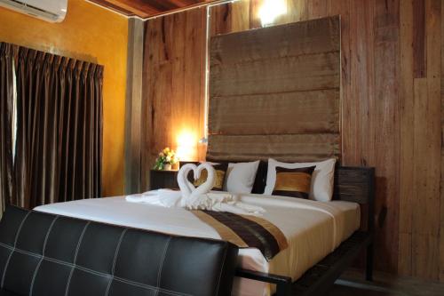 南府BAAN9NAN Home Lodge的一间卧室配有一张带两个天鹅的床