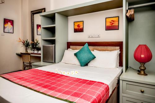 高尔小屋精品旅馆的一间卧室配有一张带红色和绿色毯子的床