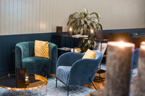 布鲁塞尔丹斯尔里特酒店的一间设有两把椅子和一张桌子的等候室