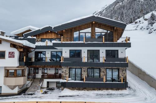 索尔登A CASA Rubin Chalet & Studio Resort的雪覆盖的山顶上的房子