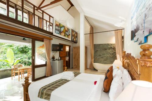 乌布乌布圣猴森林拉哈宇酒店的一间卧室设有一张大床和一个浴缸