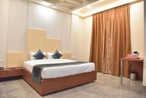 瓦拉纳西Rk格兰德酒店的一间卧室设有一张床和一个窗口