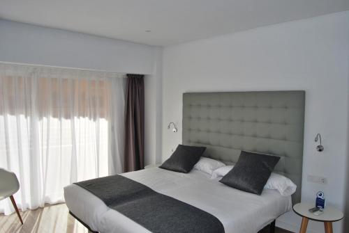 阿利坎特阿利坎特埃斯杜迪欧酒店的一间卧室设有一张大床和一个大窗户