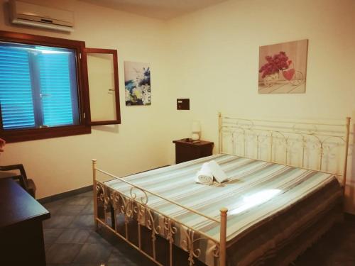 切萨雷奥港Villetta Residence Chiusurelle的一间卧室配有一张白色床架和窗户。