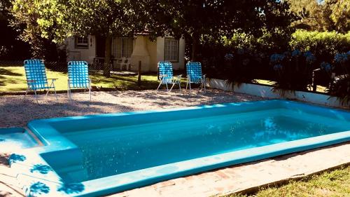 查斯科穆斯Altos de la Laguna的蓝色的游泳池配有椅子和桌子