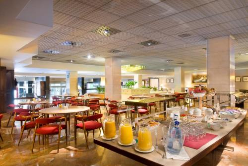 萨拉戈萨戈雅酒店的餐厅设有桌椅,提供饮品