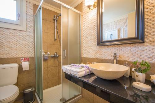 锡米Symi Nautilus Luxury Suites的一间带水槽、淋浴和卫生间的浴室