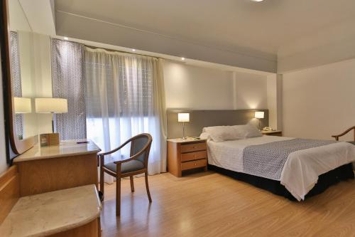 巴拉那巴拉那大酒店的酒店客房配有一张床、一张桌子和一把椅子。