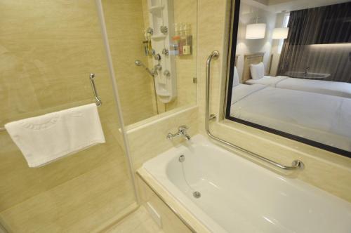 高雄康桥商旅-七贤馆的带淋浴、盥洗盆和镜子的浴室